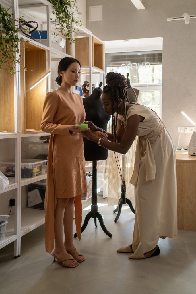 Seamstress adjusting a wedding dress on a dress form in a bridal manufacturing atelier — wedding dress manufacturing cost guide