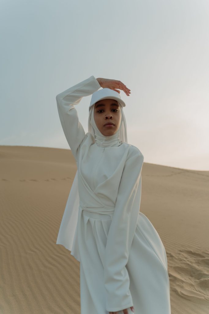 Woman wearing an elegant white long-sleeve modest dress for wholesale Muslim dresses buyers